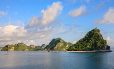Stunning view of Halong Bay's limestone islands and calm waters from a luxury cruise balcony.
