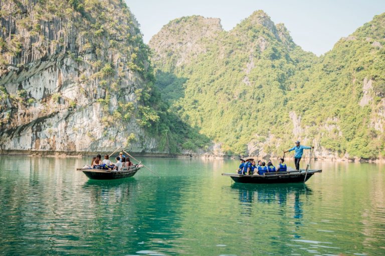Scenic Halong Bay with boats and lush green limestone karsts, peaceful and picturesque.