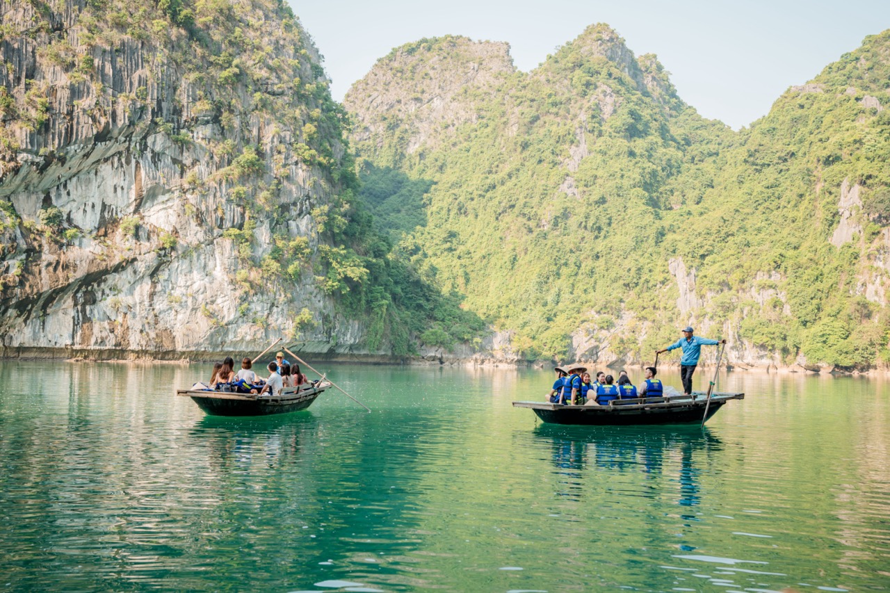 Scenic Halong Bay with boats and lush green limestone karsts, peaceful and picturesque.