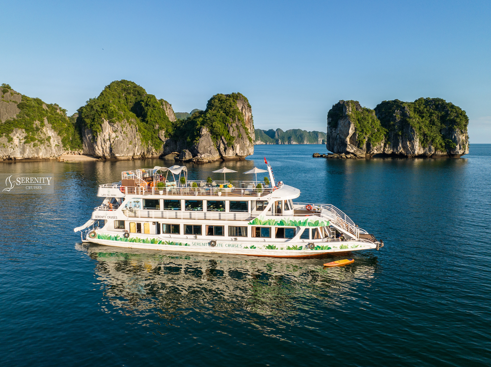 A luxurious cruise boat sailing through Halong Bay's stunning limestone karsts and emerald waters, p.