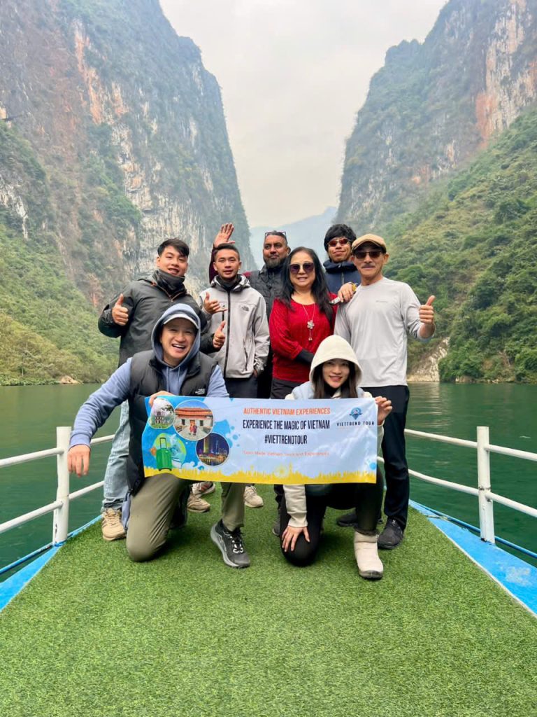 Scenic view of travelers enjoying a boat cruise in Halong Bay surrounded by towering limestone karst.