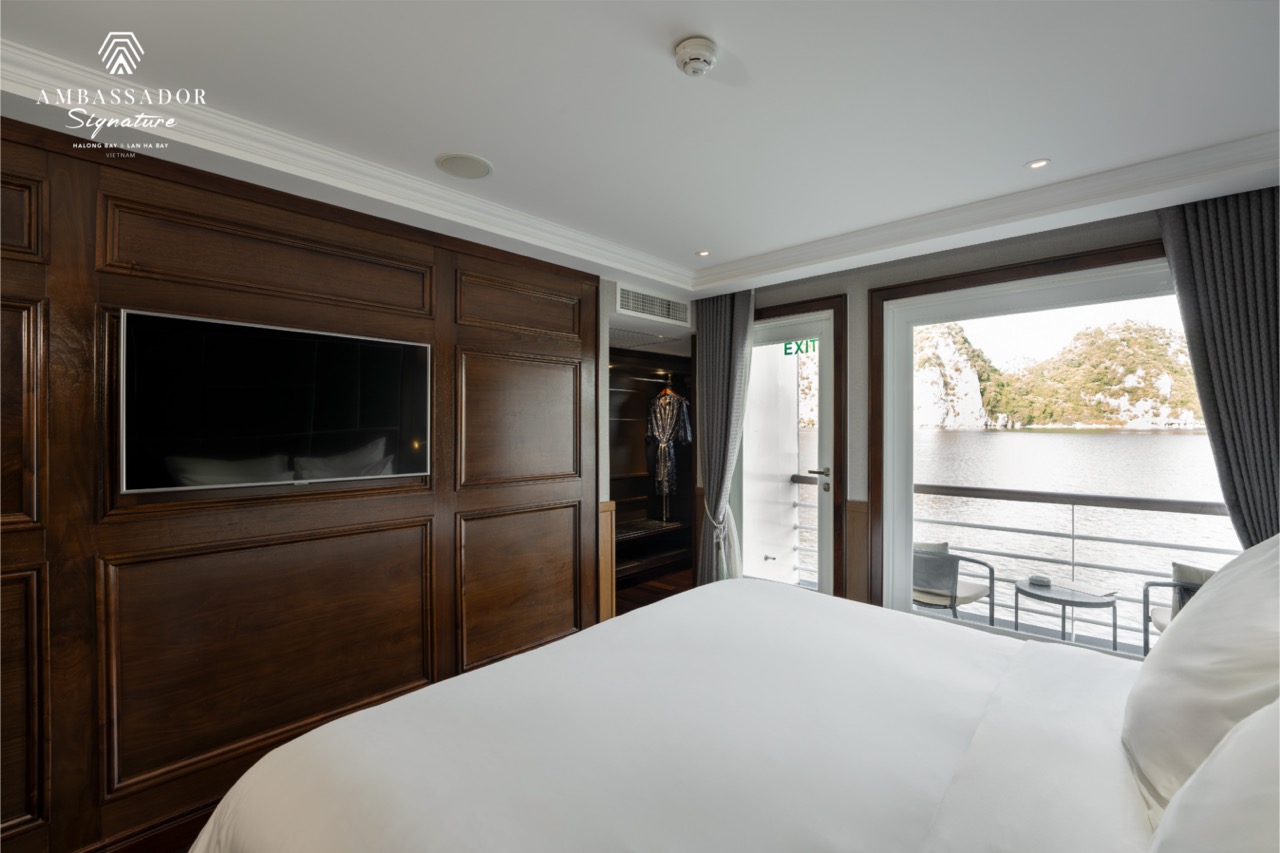 Elegant cruise room with balcony overlooking Halong Bay, ideal for luxury travel and scenic explorat.