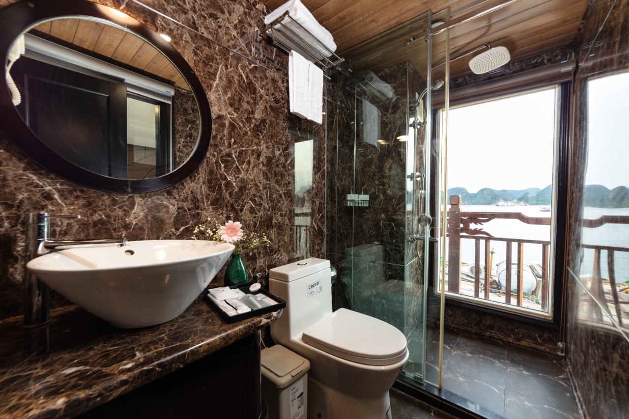 Luxury bathroom with sea view, marble surfaces, modern fixtures, and extensive natural light.