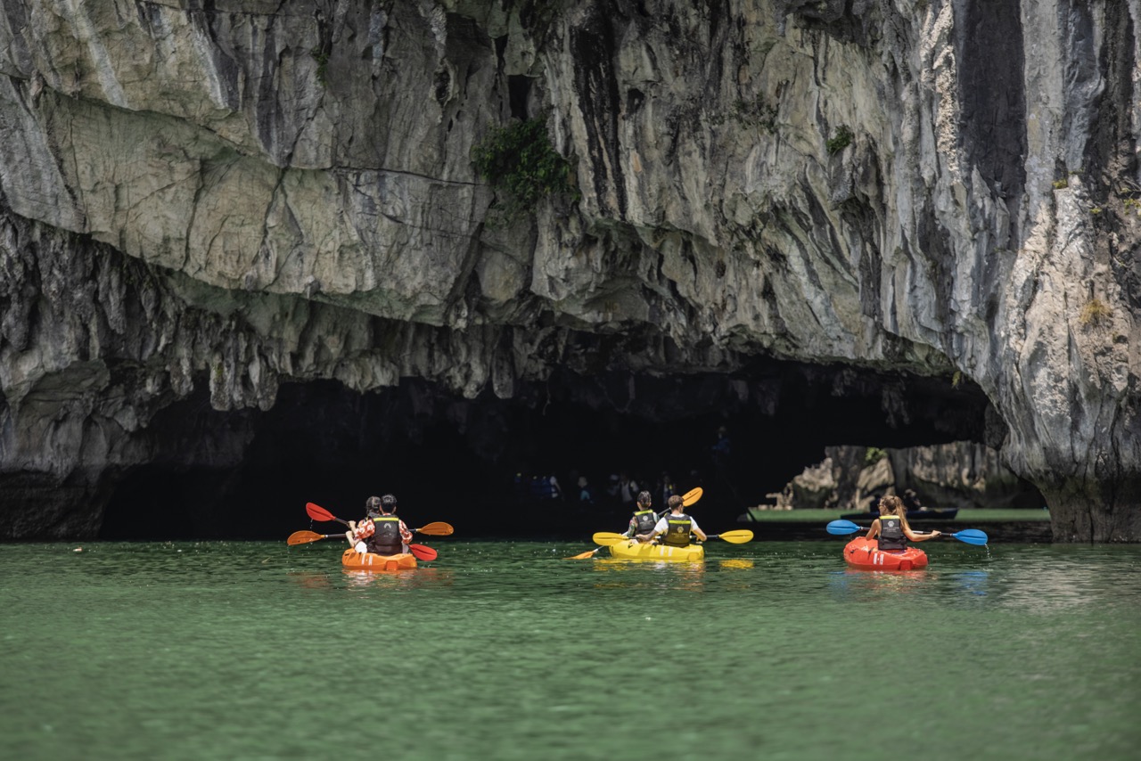 Kayaking in Halong Bay with stunning limestone cliffs and emerald waters, perfect for an adventurous.