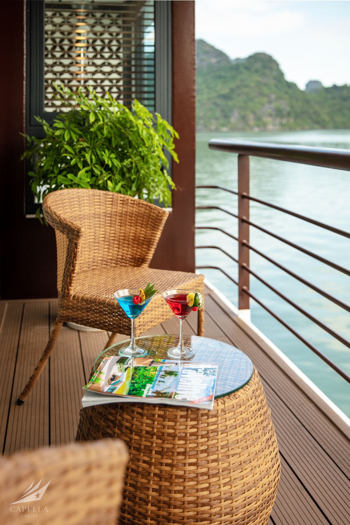 Colorful cocktails on a balcony overlooking a serene water landscape.