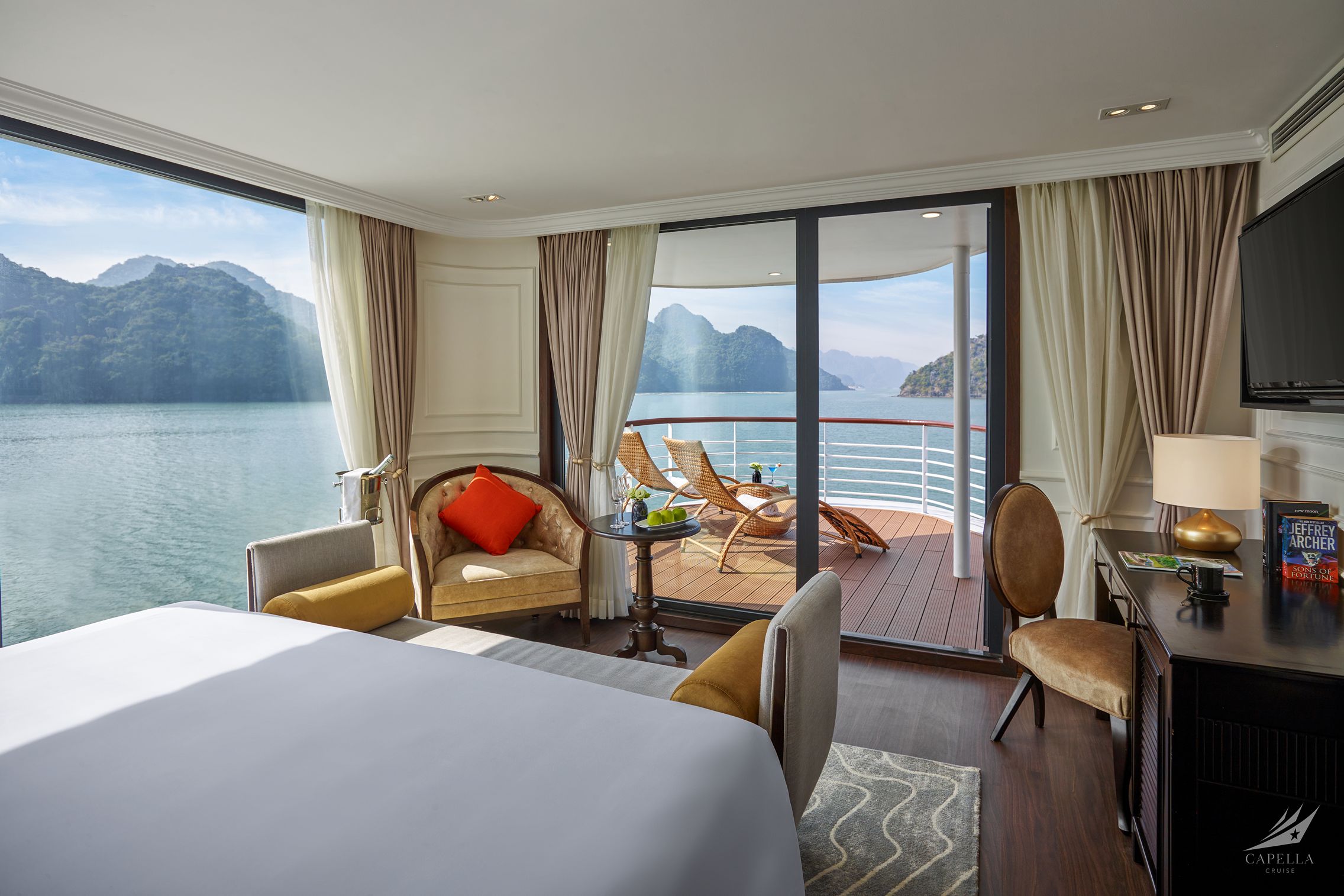 Luxurious waterfront cruise suite with private balcony and stunning bay views.