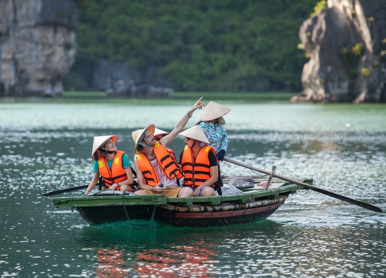 ViettrendTour group enjoying boat tour in Halong Bay, Vietnam, exploring scenic limestone islands.