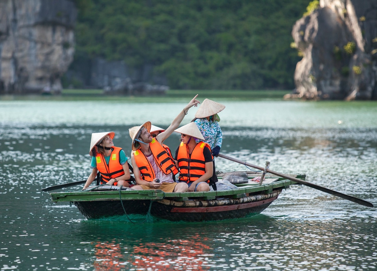ViettrendTour group enjoying boat tour in Halong Bay, Vietnam, exploring scenic limestone islands.