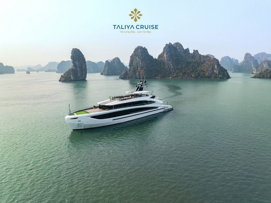 Luxury yacht cruising through scenic Lan Ha Bay with towering limestone karsts.