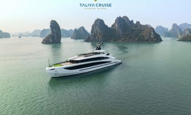 Luxury yacht cruising through scenic Lan Ha Bay with towering limestone karsts.