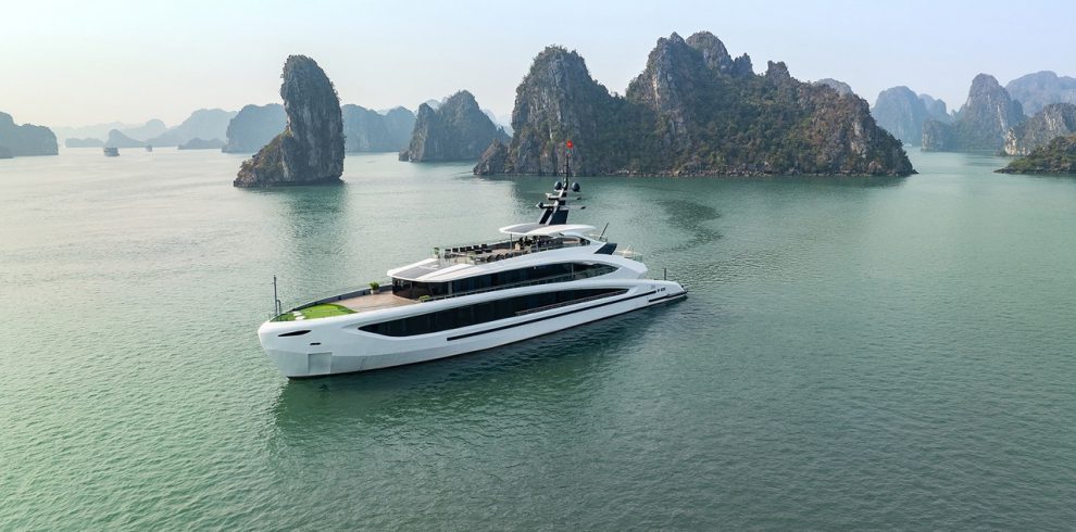 Luxury yacht cruising through scenic Lan Ha Bay with towering limestone karsts.