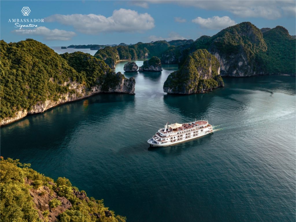 Stunning view of Halong Bay with a luxury cruise sailing among limestone karsts and emerald waters.