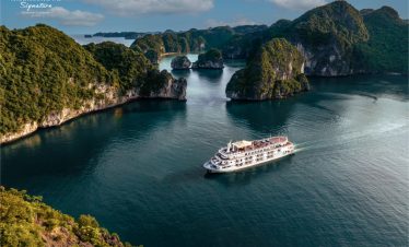 Stunning view of Halong Bay with a luxury cruise sailing among limestone karsts and emerald waters.