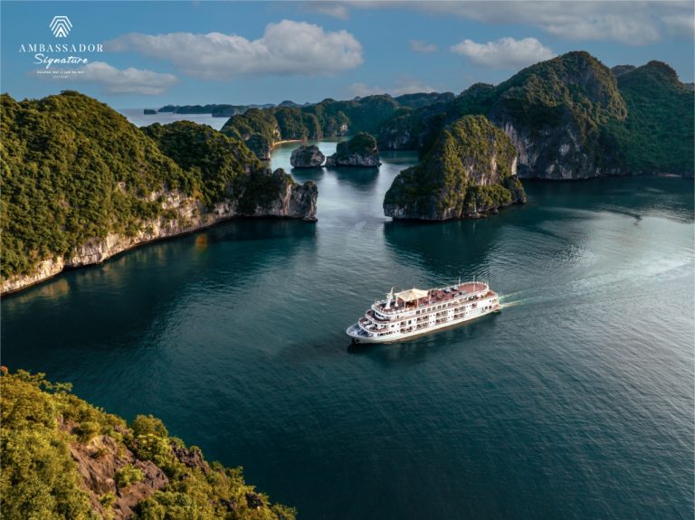Stunning view of Halong Bay with a luxury cruise sailing among limestone karsts and emerald waters.