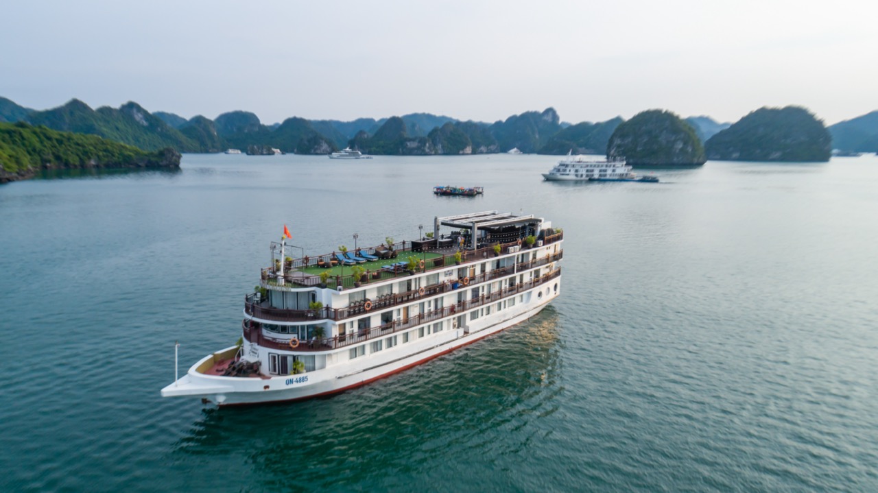 Luxury cruise ship sailing in Halong Bay, Vietnam with scenic limestone islands.