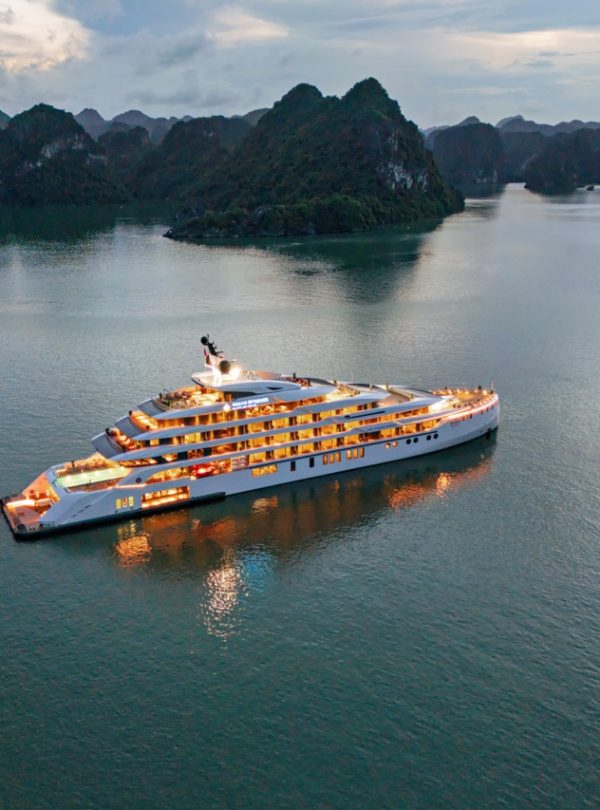 Luxurious yacht cruising Ha Long Bay in Vietnam at sunset.