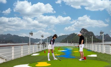 Enjoying a relaxing golf game on the deck of Mon Cheri Cruise with stunning Halong Bay scenery.