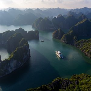 Drone view of Stellar Of The Seas weaving through dramatic karst islands in Lan Ha Bay, Vietnam. Let ViettrendTour craft your dream Halong Bay cruise itinerary.