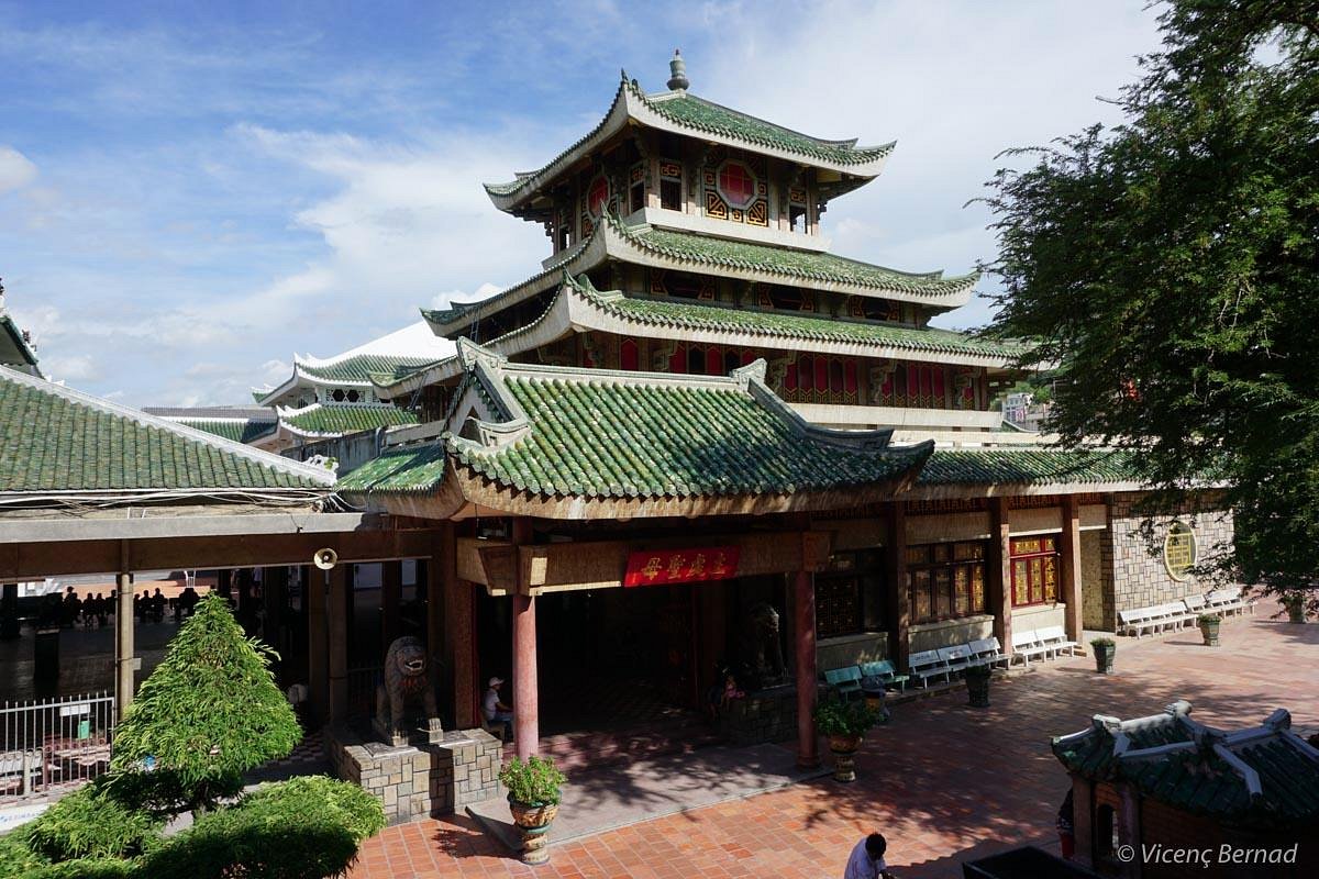 Traditional Vietnamese pagoda with green-tiled roofs and intricate woodwork in Vietnam.