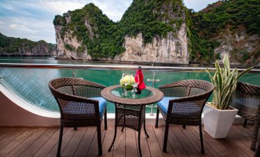 Tranquil cruise balcony with scenic limestone karsts and turquoise waters, perfect for luxury travel.