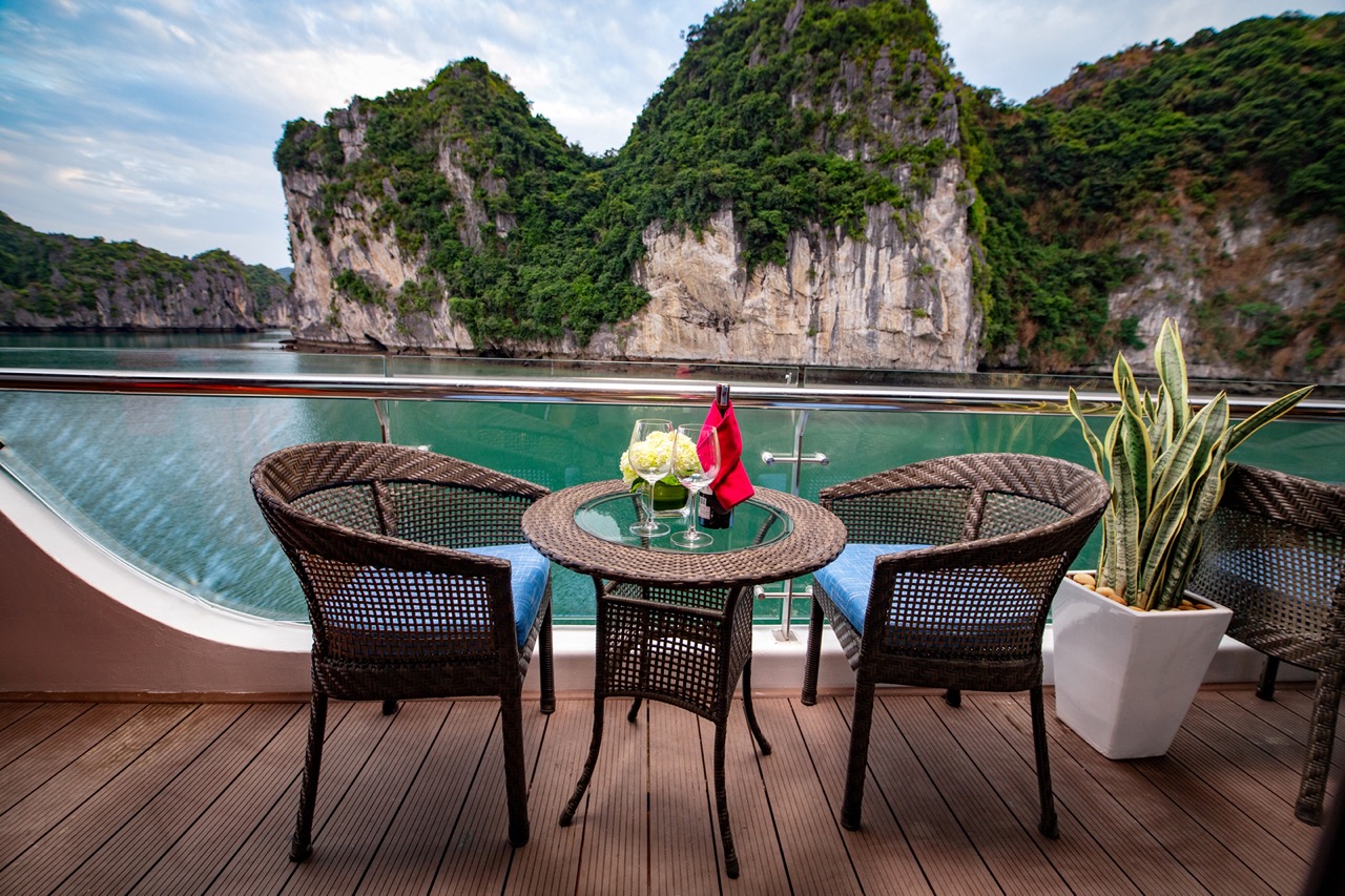 Tranquil cruise balcony with scenic limestone karsts and turquoise waters, perfect for luxury travel.