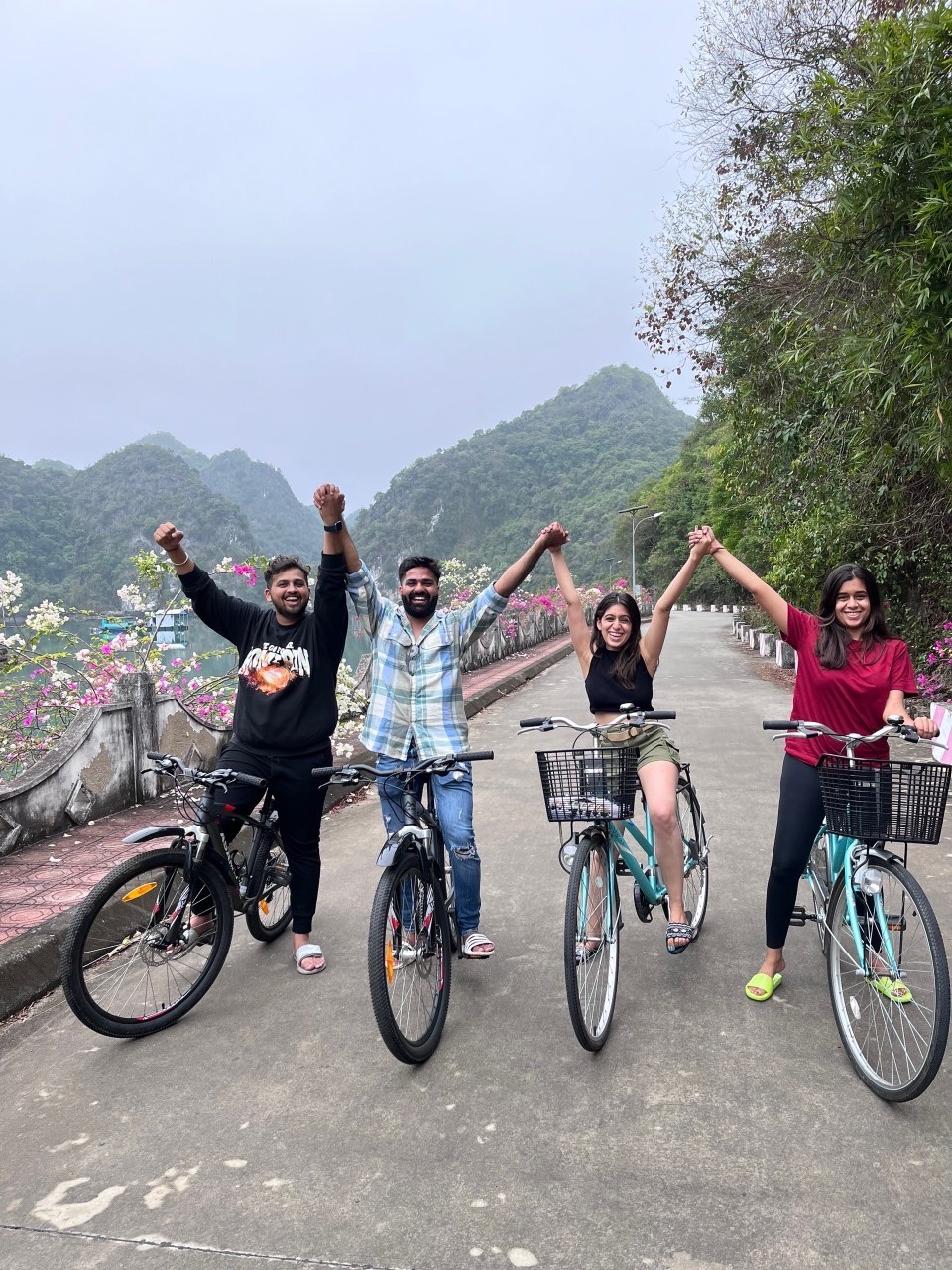 Cyclists enjoying a joyful ride along a mountain road in Lan Ha Bay, surrounded by lush greenery and.