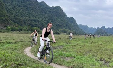 Mountain biking along lush trails in Lan Ha Bay with scenic mountain views and a joyful atmosphere.