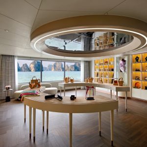 Elegant boutique shop with sea view, showcasing luxury handbags and accessories, bright interior, modern design, coastal scenery.