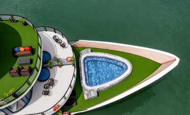 Stunning aerial view of a luxury cruise in Halong Bay featuring an infinity pool and spacious deck,.