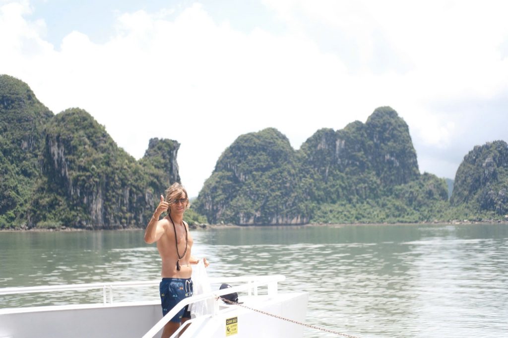 Stunning Lan Ha Bay scene with a woman enjoying a cruise balcony, lush limestone islands, and tranqu.