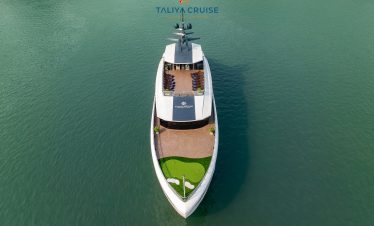 Aerial view of luxury cruise boat sailing on Halong Bay with calm waters and scenic limestone karsts.