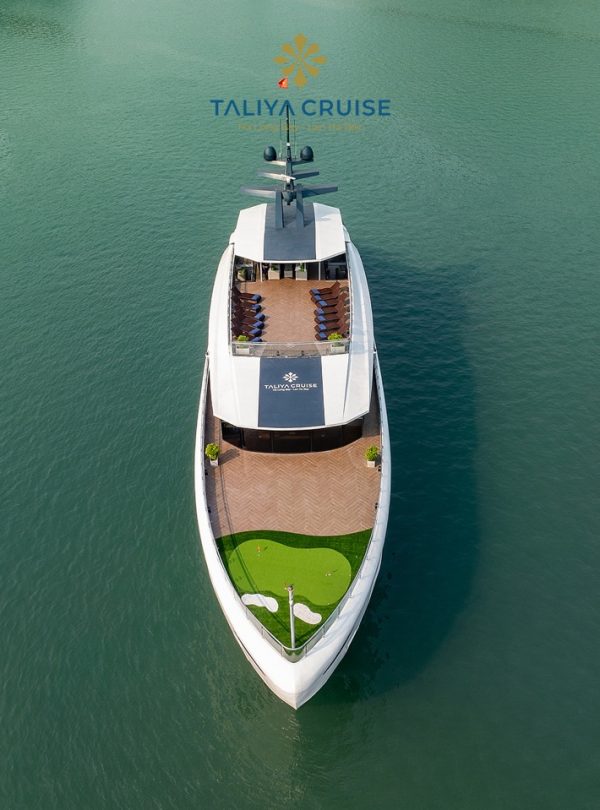 Aerial view of luxury cruise boat sailing on Halong Bay with calm waters and scenic limestone karsts.