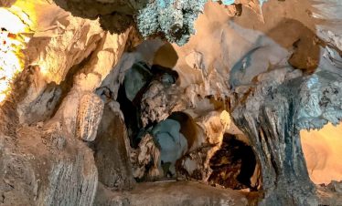 Cave exploration scene in Halong Bay with stunning stalactites and stalagmites, adventurous atmosphe.