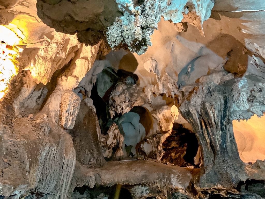 Cave exploration scene in Halong Bay with stunning stalactites and stalagmites, adventurous atmosphe.