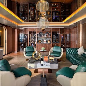 Luxurious modern lounge with stylish green and white seating, wooden accents, and elegant lighting.