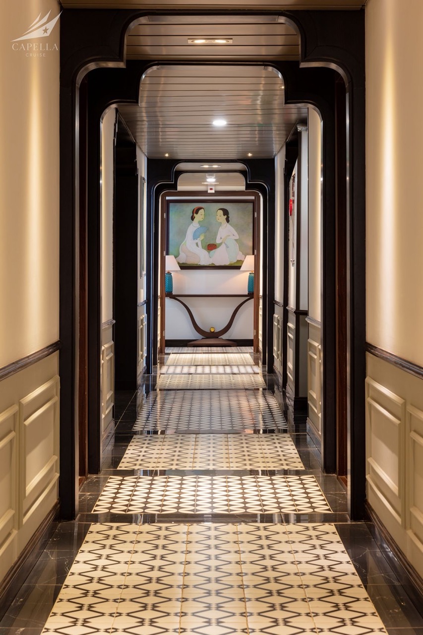 Elegant cruise hallway with intricate tile flooring and artistic wall decor.
