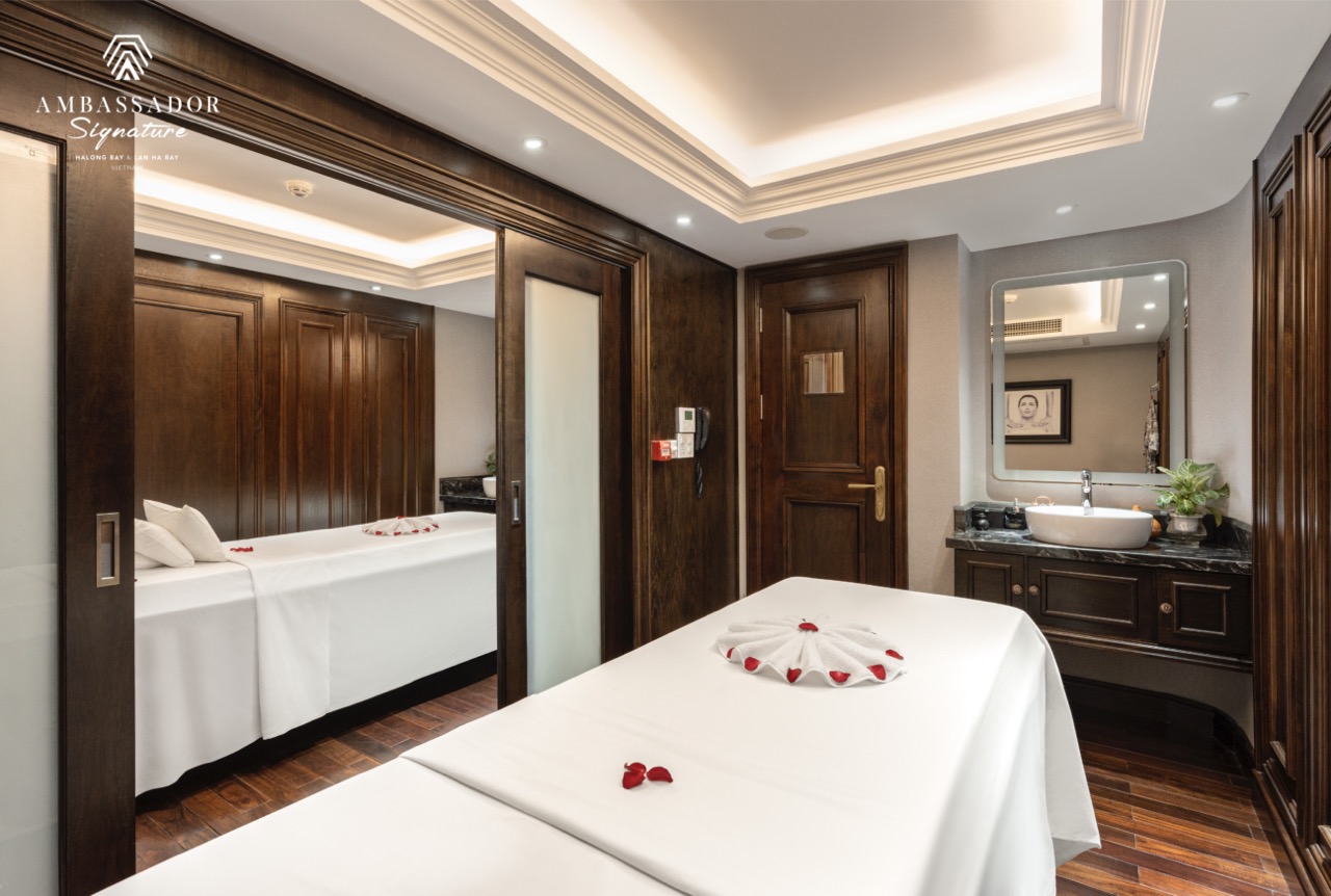 Luxurious cruise cabin with elegant wooden decor, cozy bed, and modern amenities on Halong Bay.