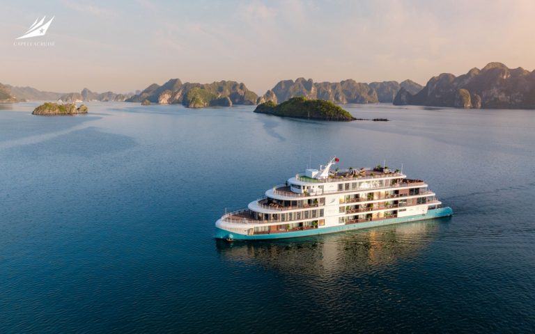 Luxury cruise boat on Ha Long Bay, Vietnam, scenic island views, tropical ocean tour.