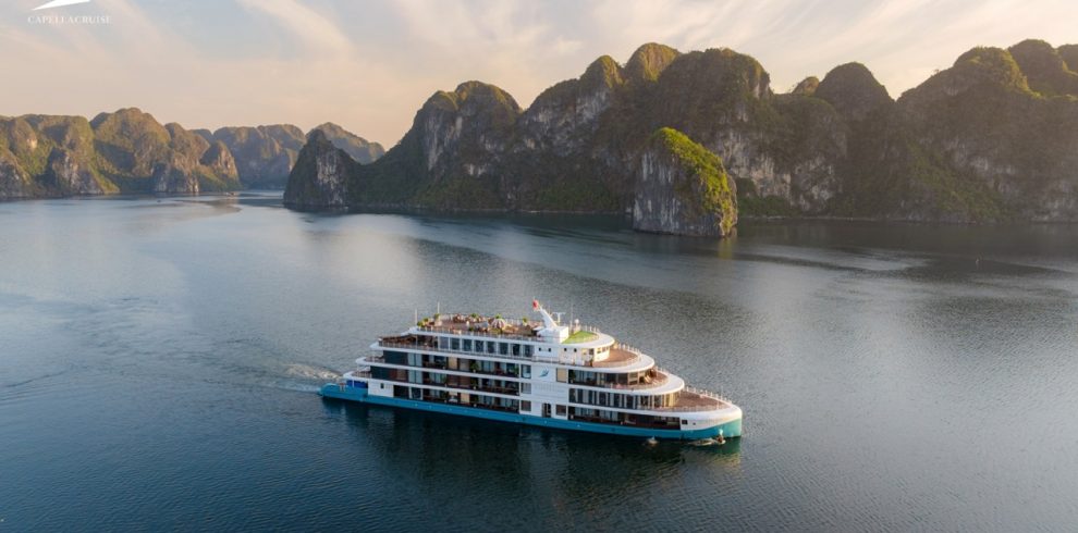 Luxury cruise boat sailing through stunning limestone karsts on Halong Bay, Vietnam.