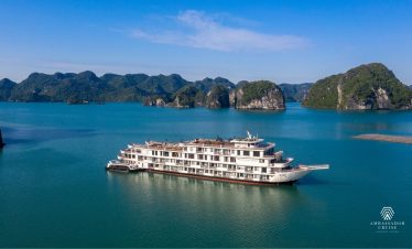 Ambassador Cruise Halong Bay ship sailing through turquoise waters of Halong Bay, scenic limestone islands, peacef.