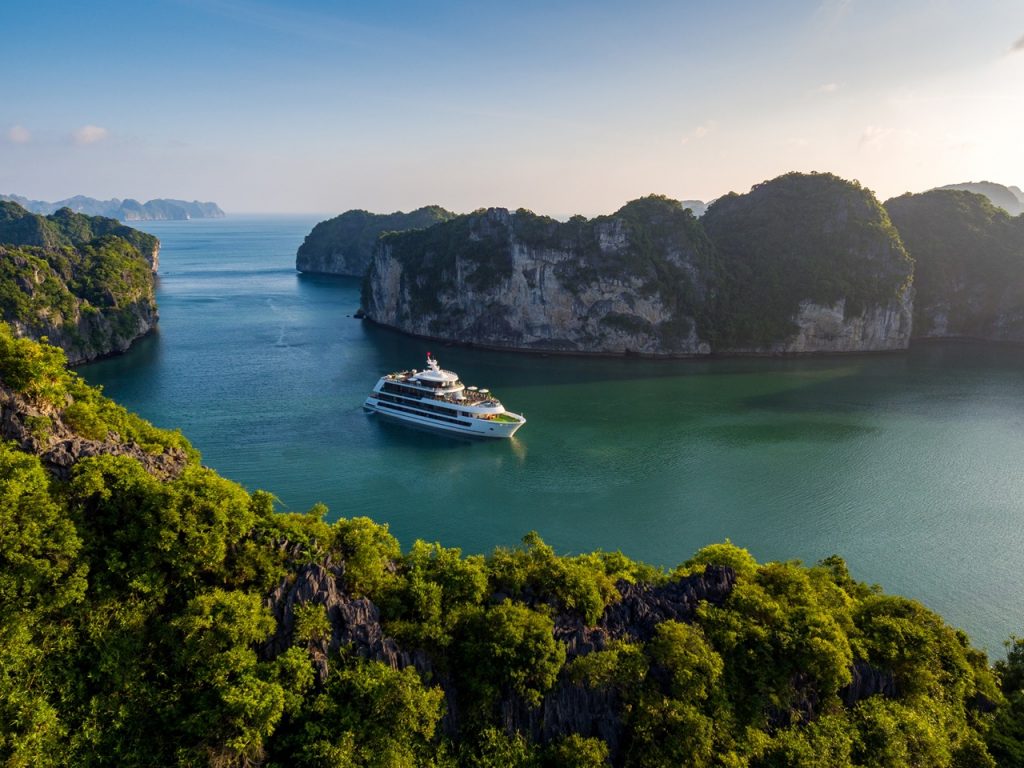 Luxurious yacht sailing between limestone karsts in Halong Bay, Vietnam.