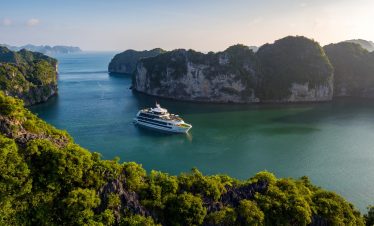 Luxurious yacht sailing between limestone karsts in Halong Bay, Vietnam.