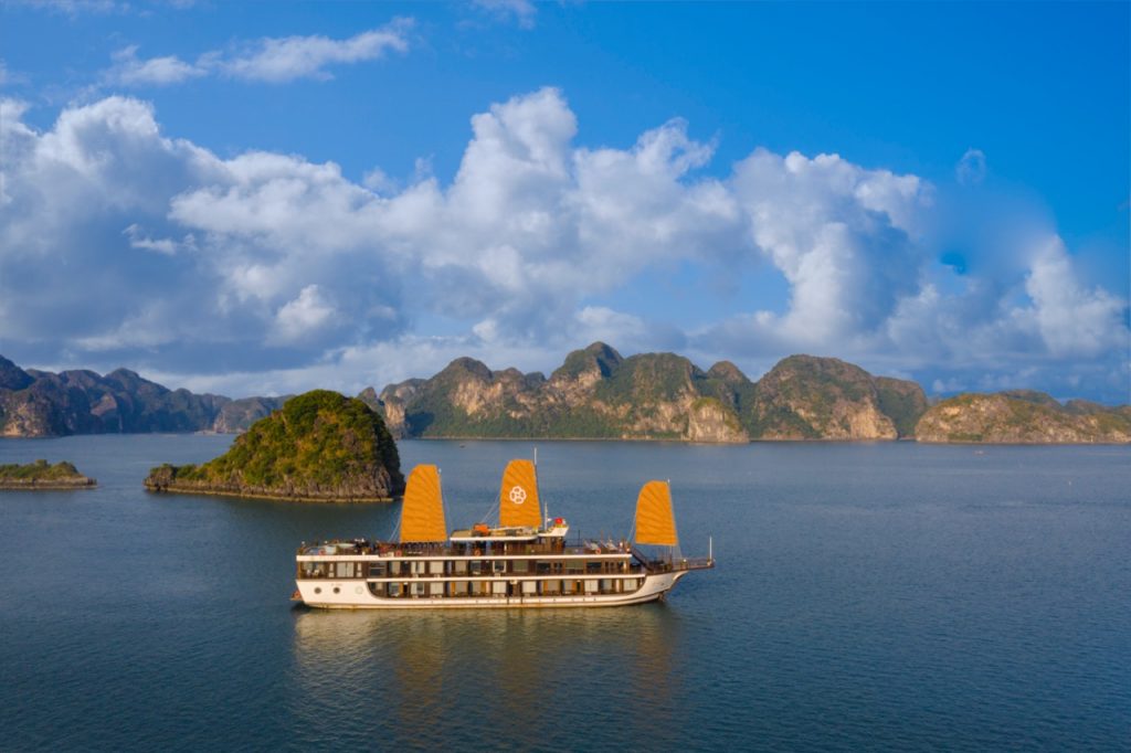 Beautiful Halong Bay landscape with boat sailing on calm waters.