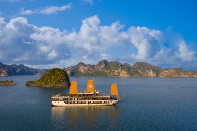 Beautiful Halong Bay landscape with boat sailing on calm waters.