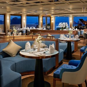 Elegant cruise ship restaurant with ocean views and luxurious interior decor.