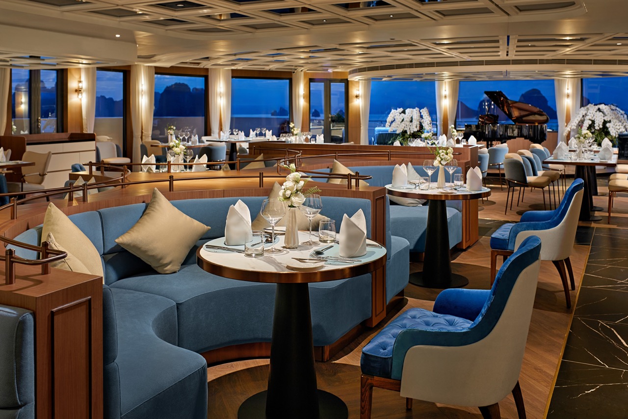 Elegant cruise ship restaurant with ocean views and luxurious interior decor.