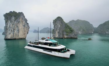 Stunning Lan Ha Bay scenery with a luxury cruise boat and towering limestone islands.