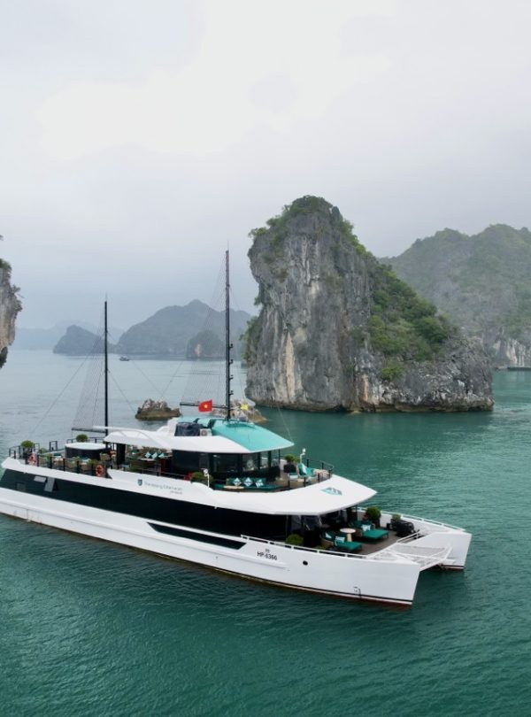 Stunning Lan Ha Bay scenery with a luxury cruise boat and towering limestone islands.