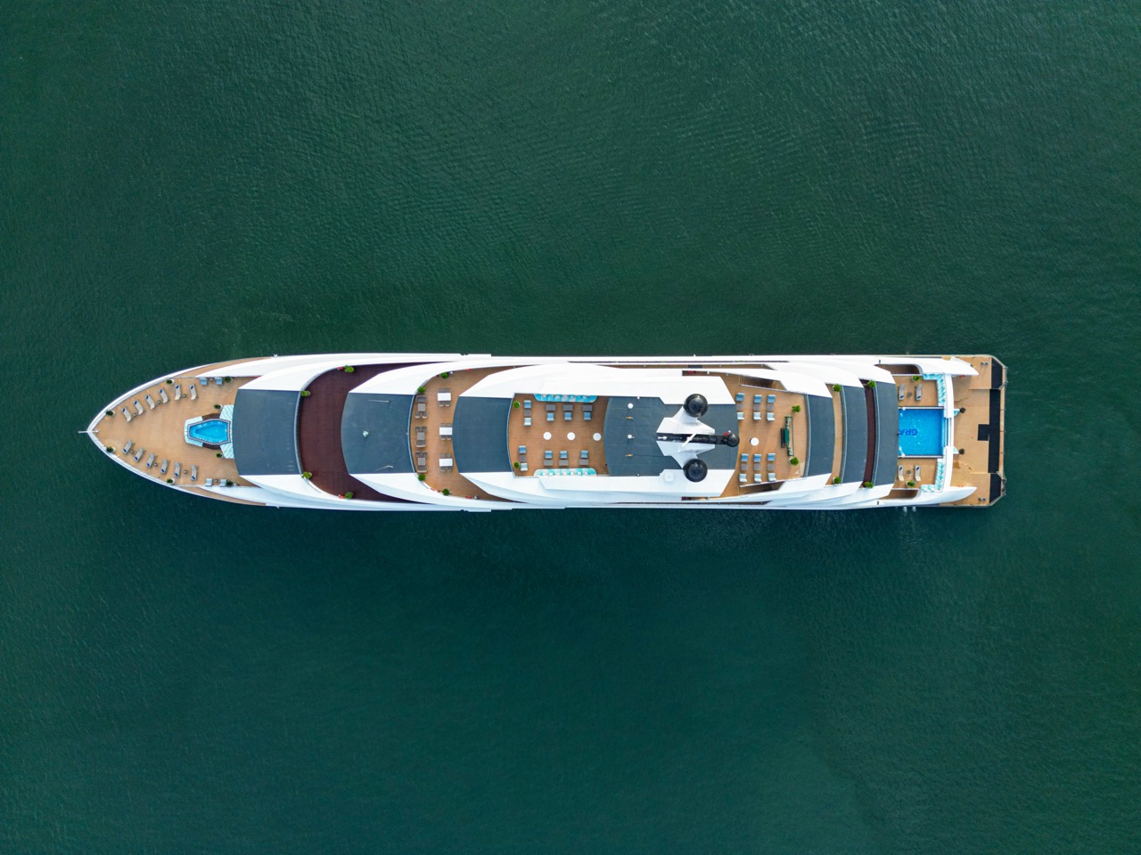 Luxury yacht cruising in emerald waters, perfect for Vietnam island tours and private charters.