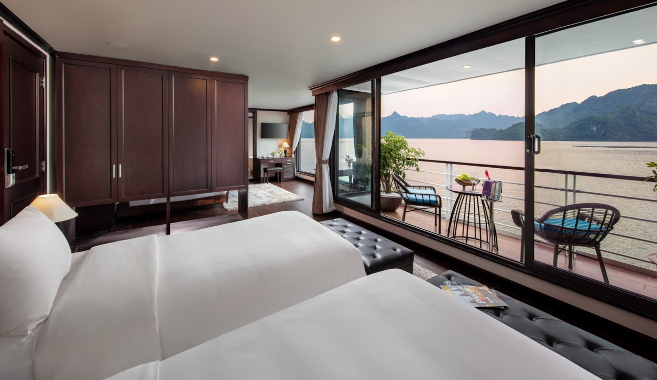Stunning view from a luxury cruise balcony overlooking Halong Bay's emerald waters and limestone kar.